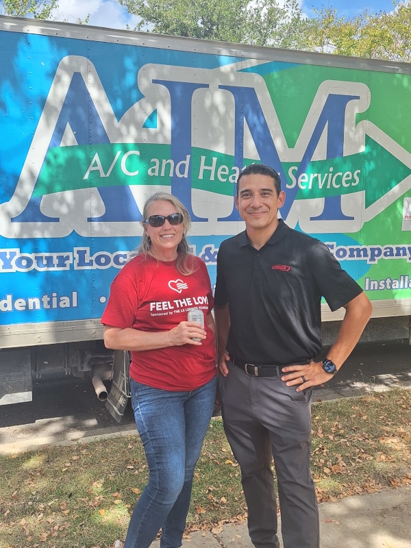 aim hvac technician standing next to the lennox representative in front of the aim ac and heating services truck