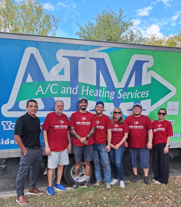 the aim ac and heating services team standing next to the lennox representative in front of the aim truck